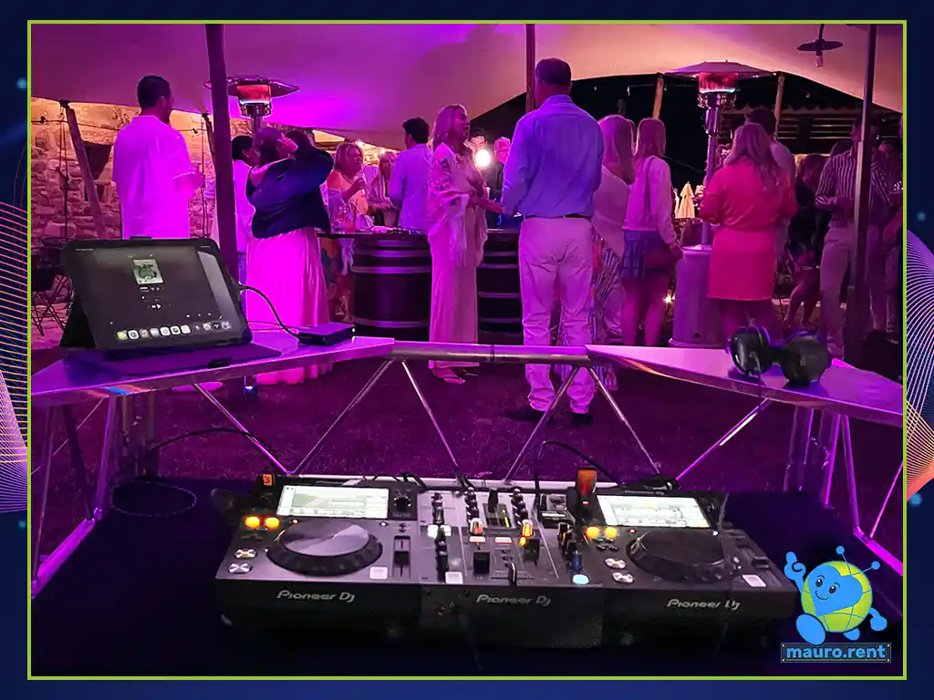 Wedding guests dancing and gathered close to the professional audio DJ booth setup
