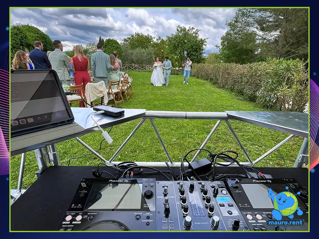 Bride entering the outdoor ceremony wedding layout monitored behind Pioneer DJ deck setup