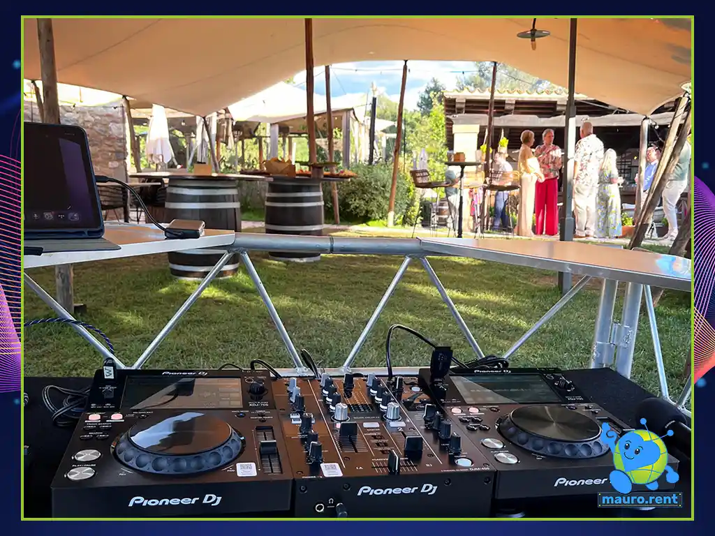 Over the shoulder view of Pioneer DJ booth looking towards the bar area at wedding event