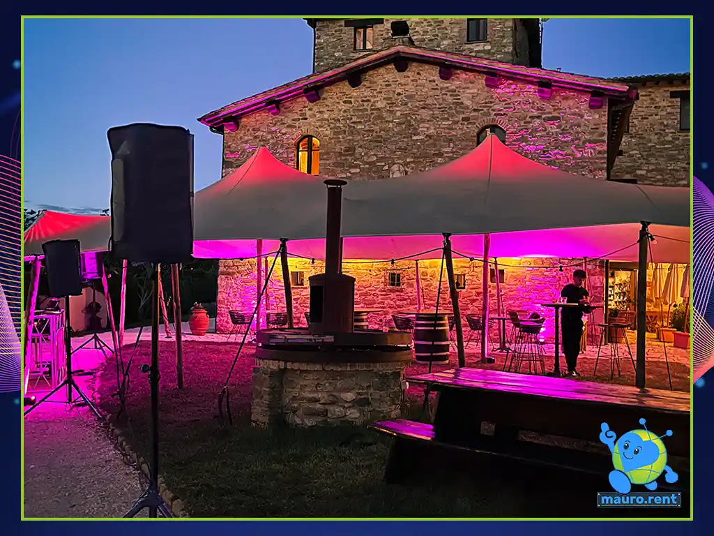 Panoramic view of Borgo Castello Panicaglia wedding lighting with purple wireless battery uplights and RCF speakers