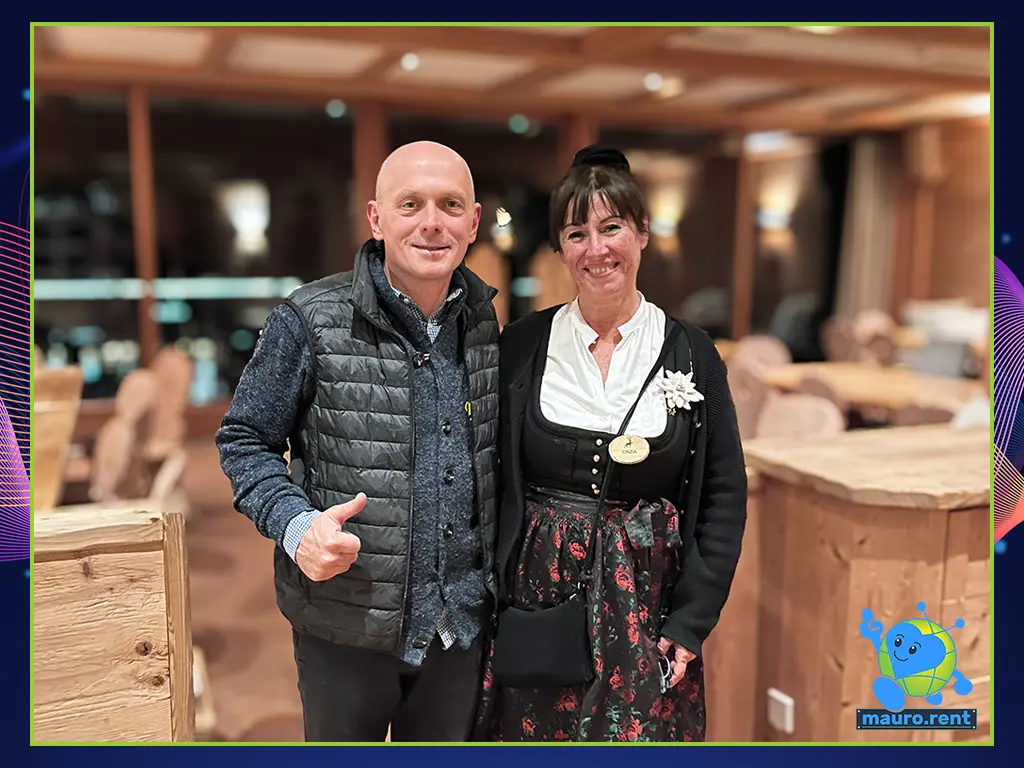Mauro Panzarola posing with Cinzia, the Wedding Planner from Hotel Kolfuschgerhof, wearing a traditional Tirolese dirndl dress, inside the Col Pradat lodge.