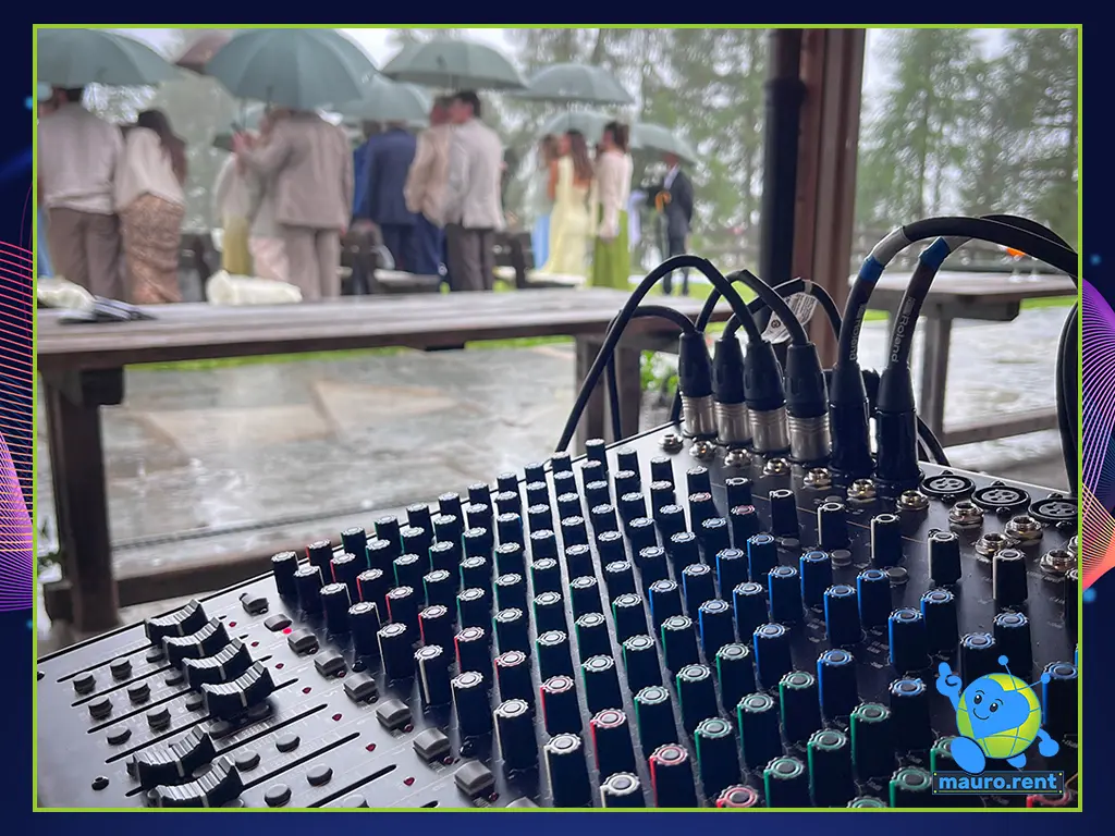 Close-up of the RCF F 16XR mixing console with channels configured for the ceremony against a background of heavy rain outside the Col Pradat lodge windows.