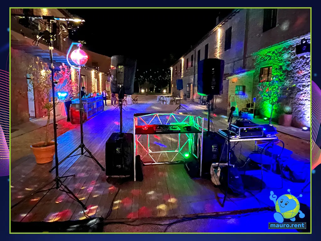 Behind-the-scenes wide shot of the dance floor setup at Terre di San Galgano, showcasing clean DJ booth cabling and a distant RCF Art 915-A speaker.