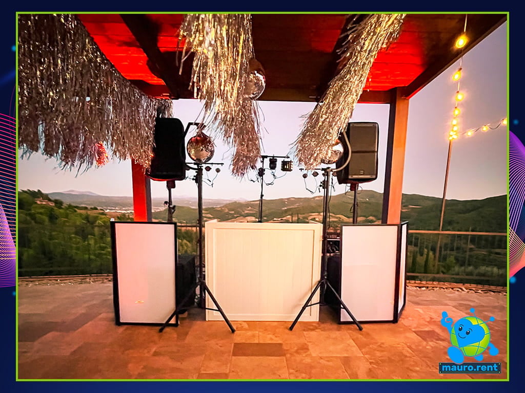 Custom white wooden DJ booth with orange battery uplights for Mamma mia party at La Torre di Celle